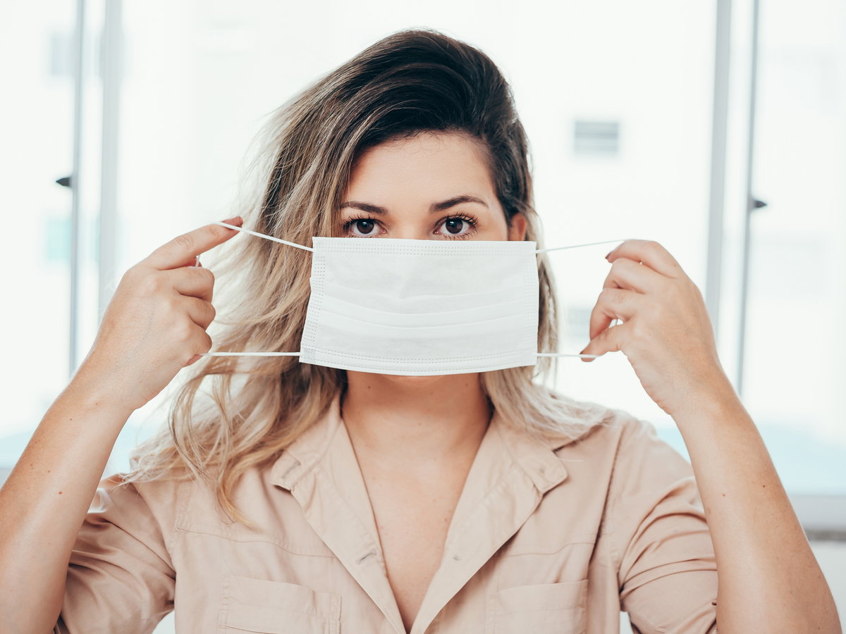 Frau setzt Maske auf