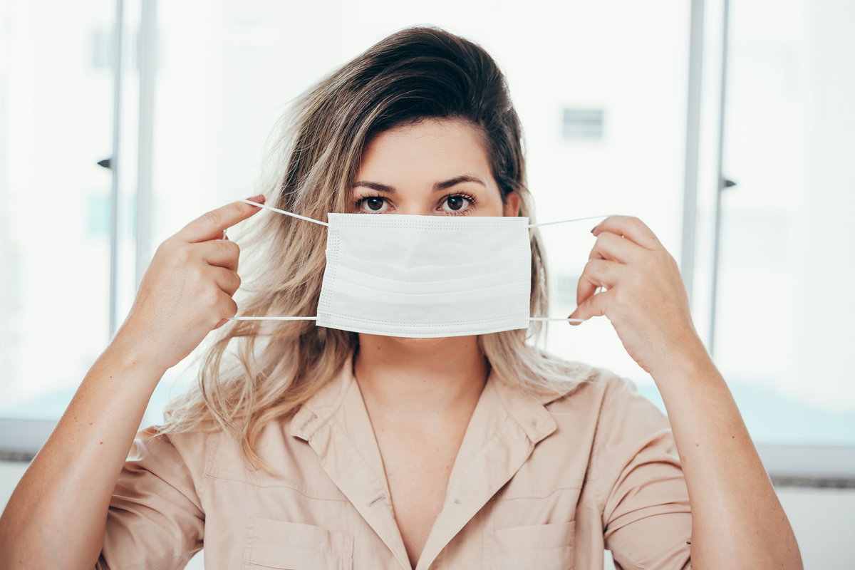 Frau setzt Maske auf