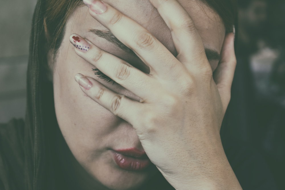 Frau schlägt Hand vors Gesicht