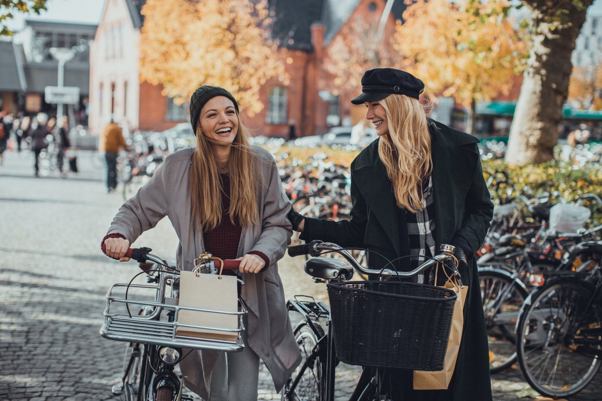 Freundinnen mit Fahrrädern lachen