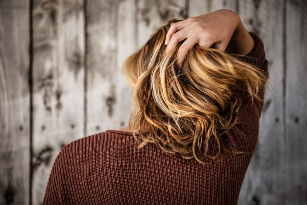 Frau fährt mit Hand durch Haare