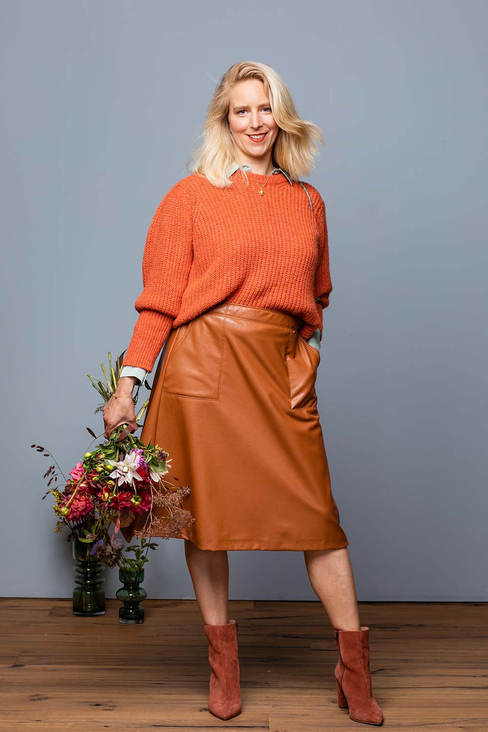 Umstyling: Vanessa mit einem orangenen Pullover und Lederrock
