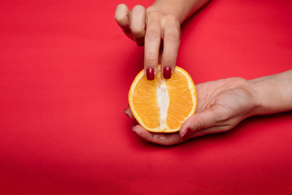 Frau hält aufgeschnittene Orange