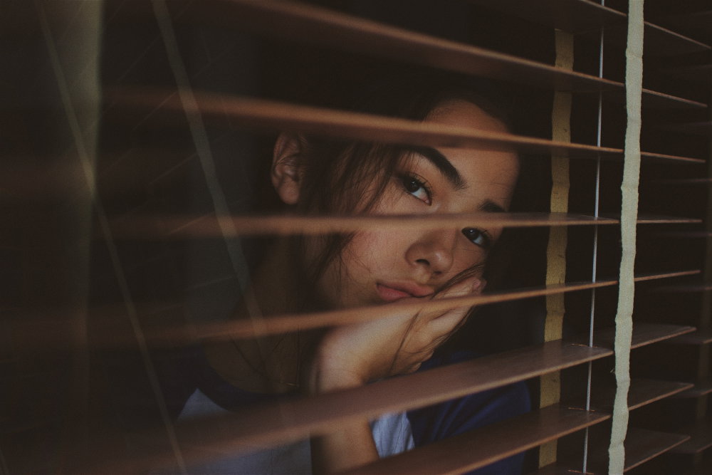 Frau schaut aus Fenster