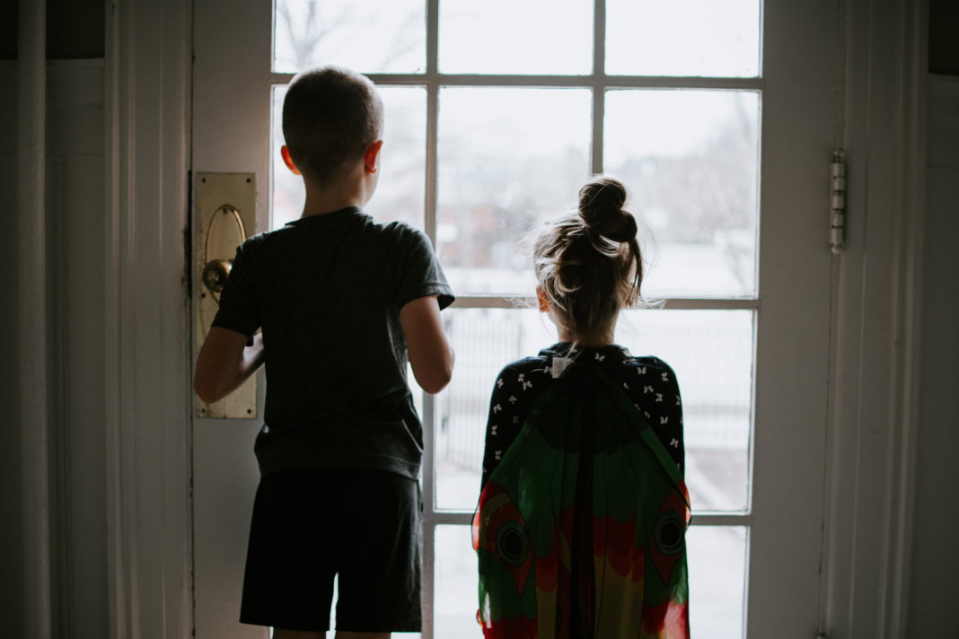 Kinder schauen aus Fenster