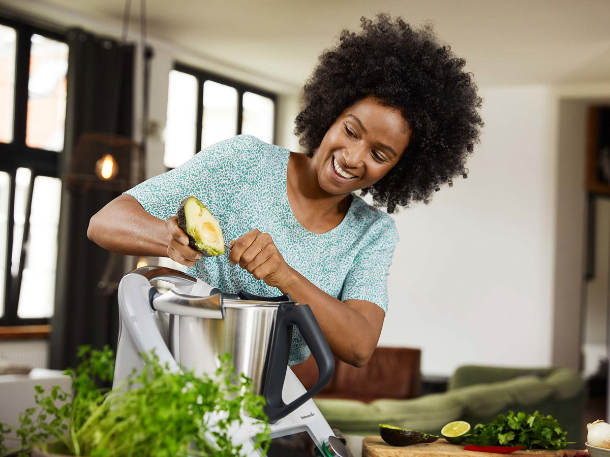 Frau kocht mit Thermomix