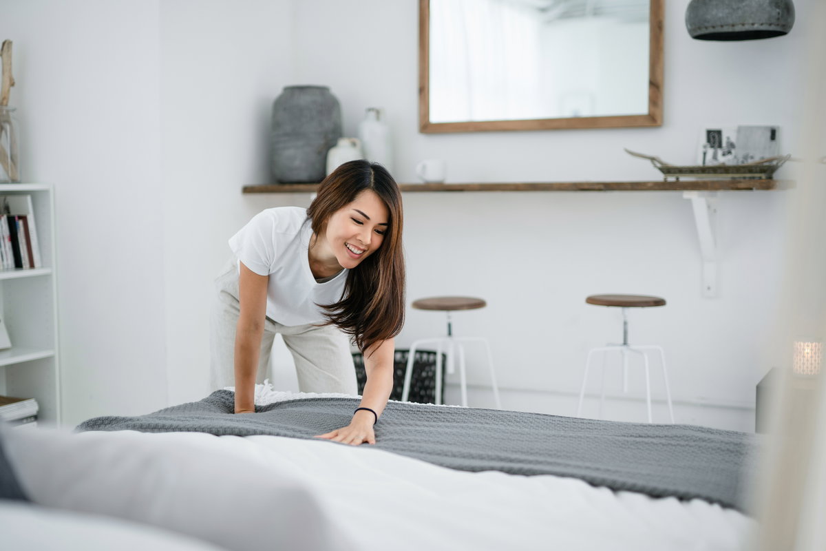 Frau macht das Bett