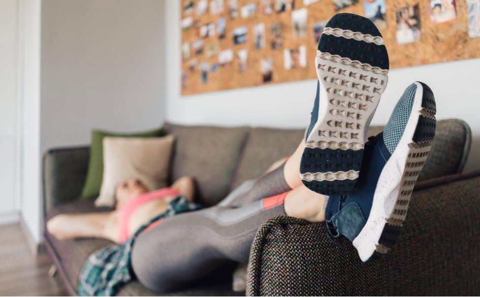 Frau in Sportkleidung auf der Couch