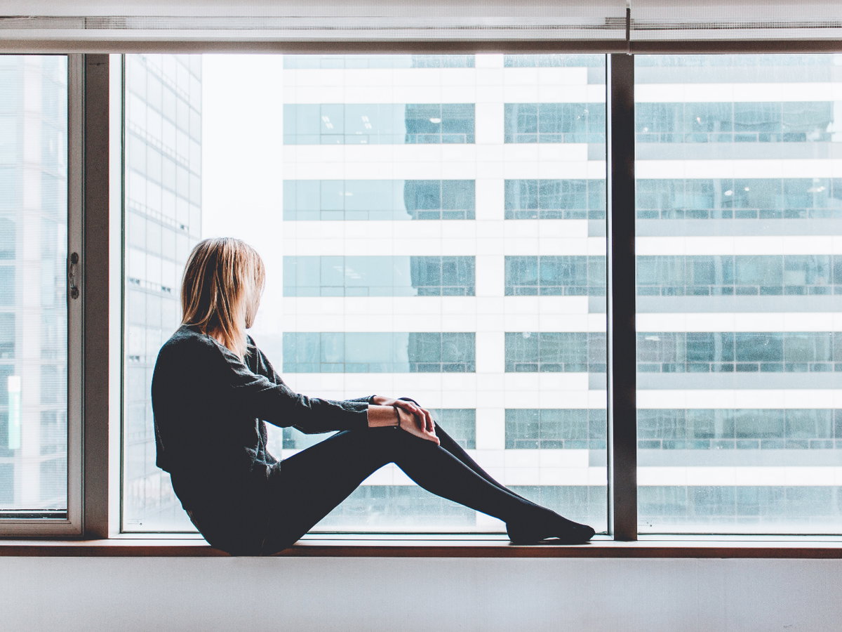 Frau sitzt am Fenster