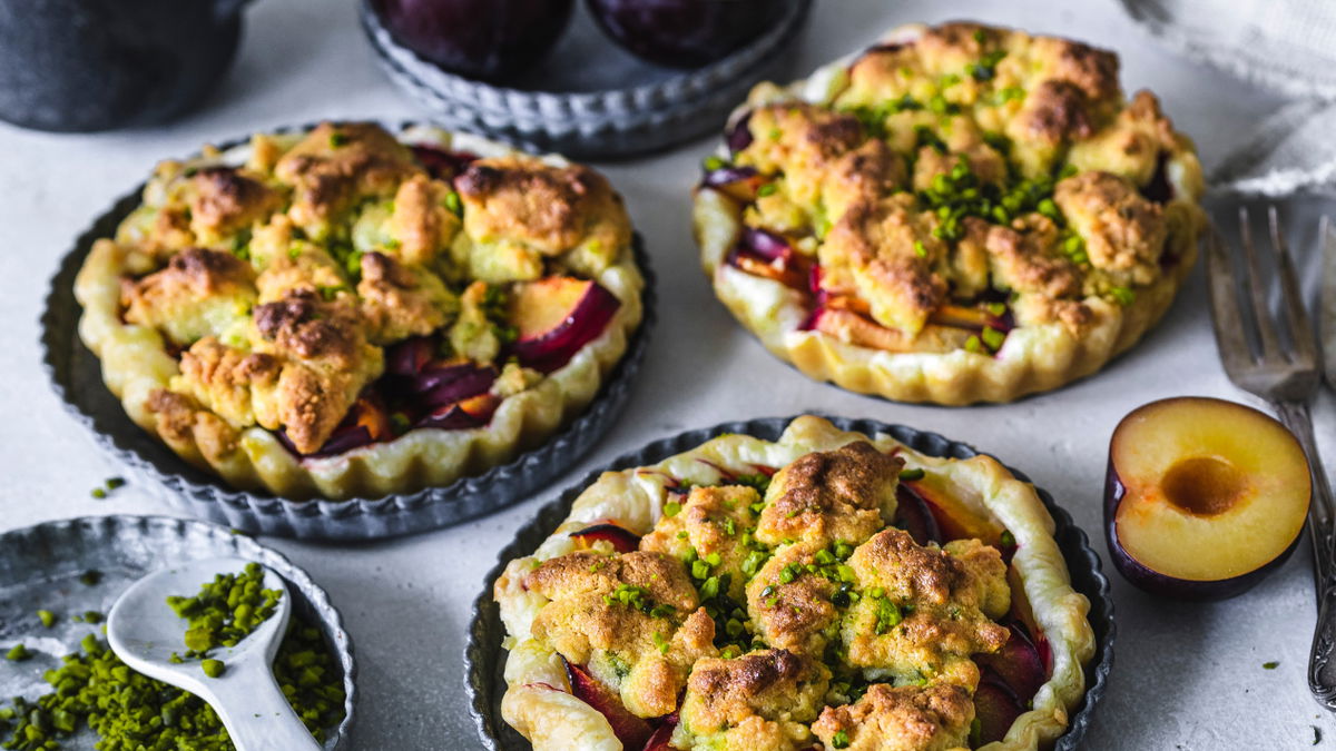 Unser Rezept für leckere Pflaumen-Torteletts mit Pistazien-Streuseln