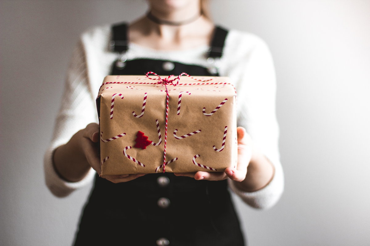 Frau überreicht Weihnachtsgeschenk