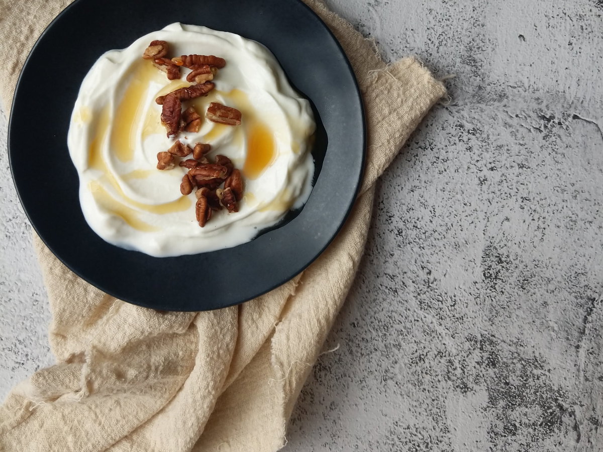 Skyr mit Nüssen in einer schwarzen Schüssel.