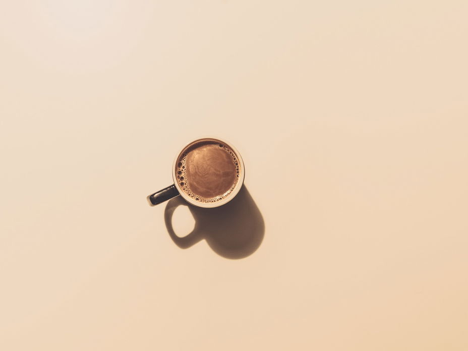 Kaffeetasse auf braunem Hintergrund.
