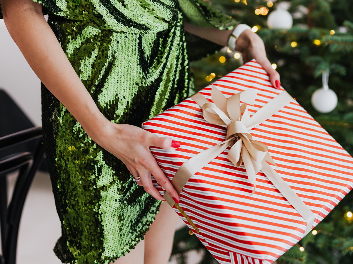 Frau überreicht ein Weihnachtsgeschenk.