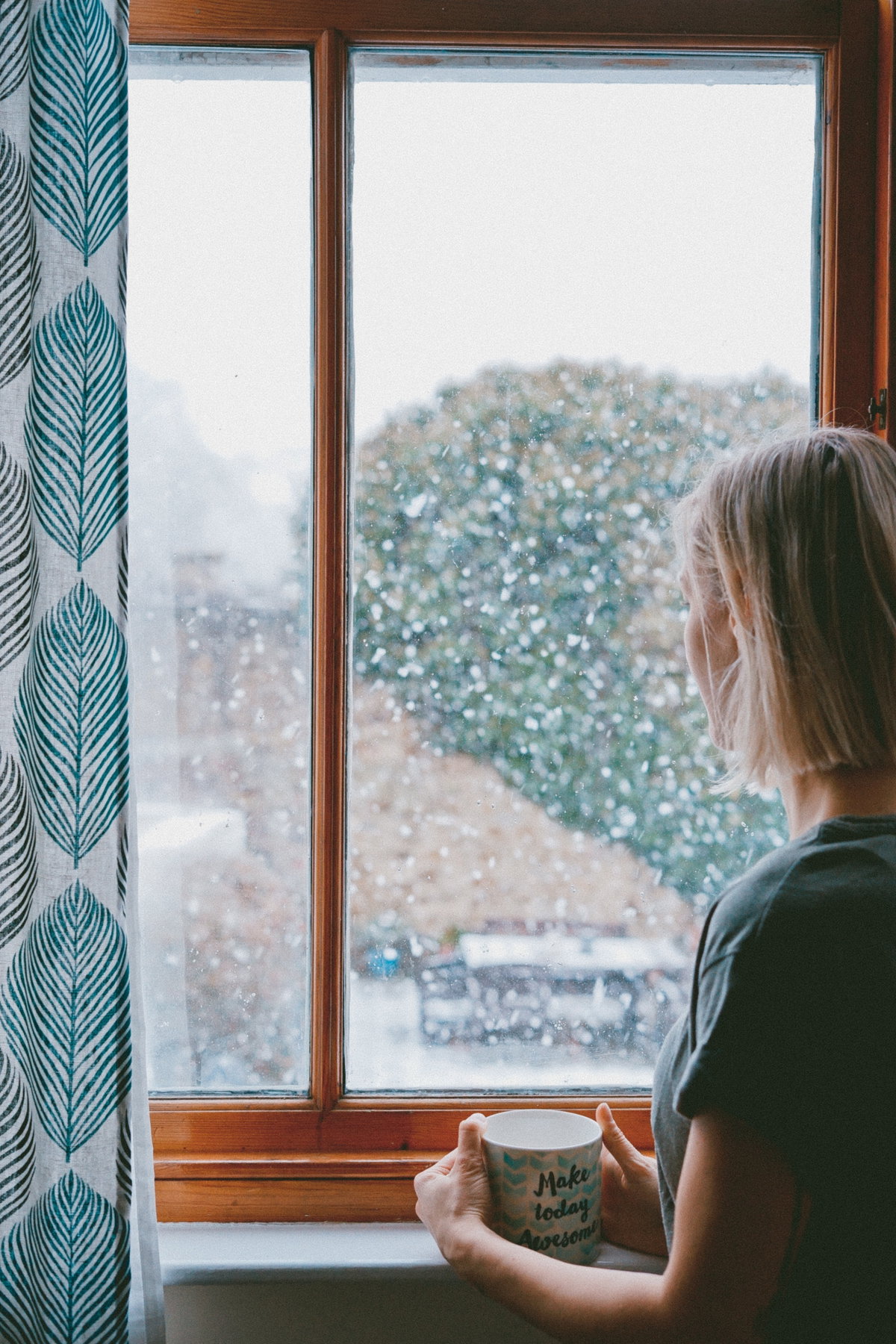 Frau steht am Fenster