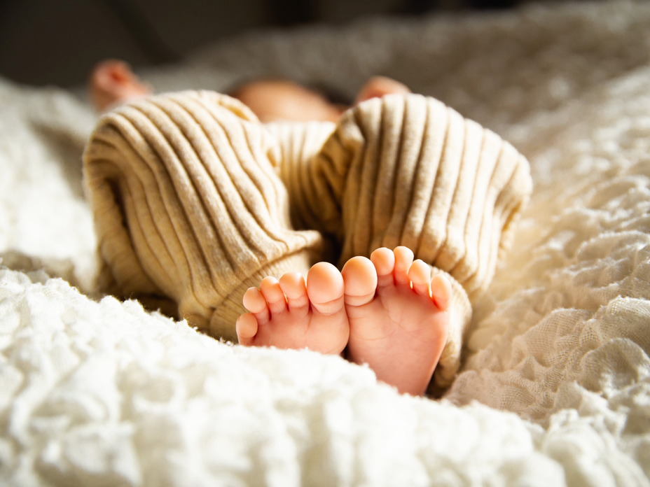 Baby liegt auf dem Bett