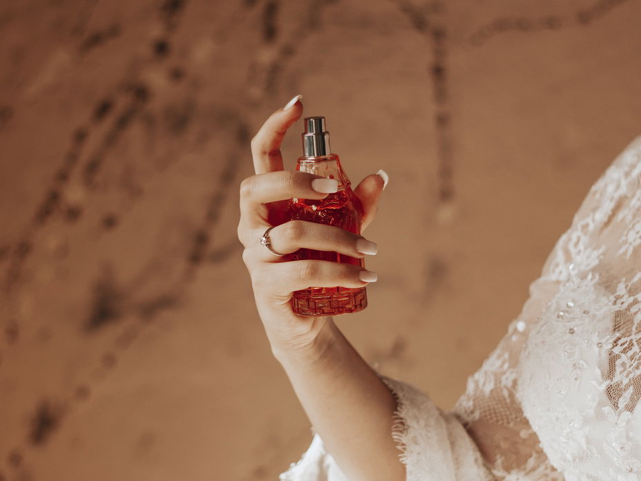 Frau trägt Parfum mit Amber auf.
