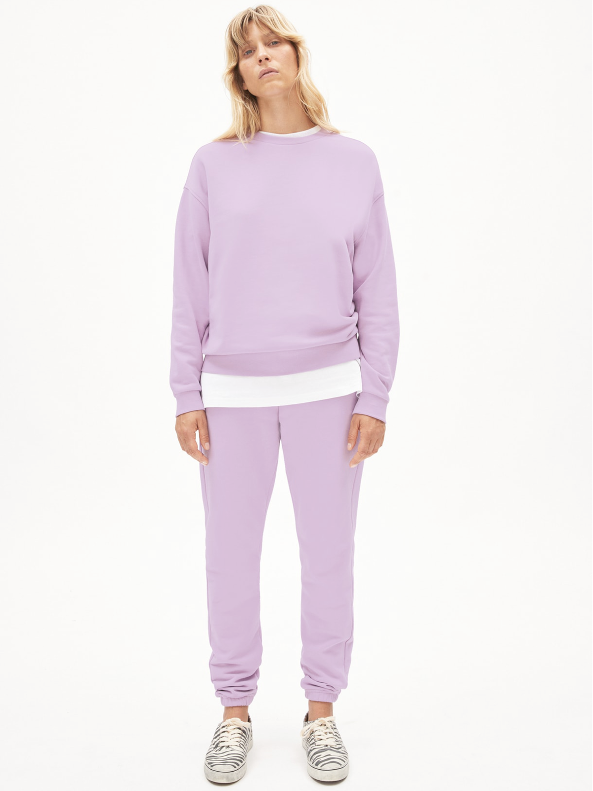 Frau trägt Jogginganzug in Bonbonfarbe von Armedangels.