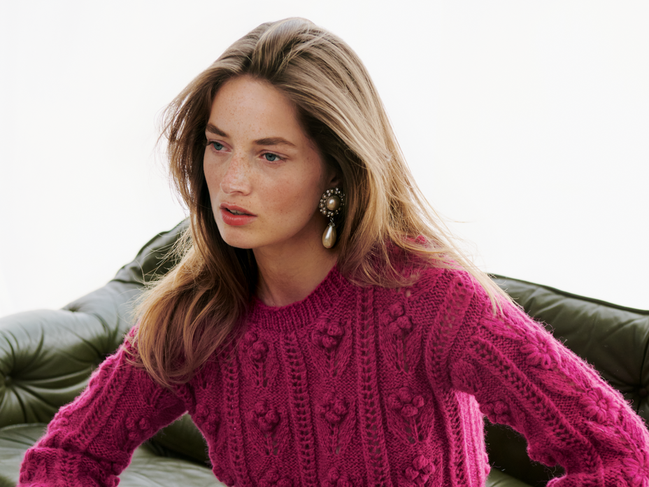 Frau in pinkem Zopfstrickpullover