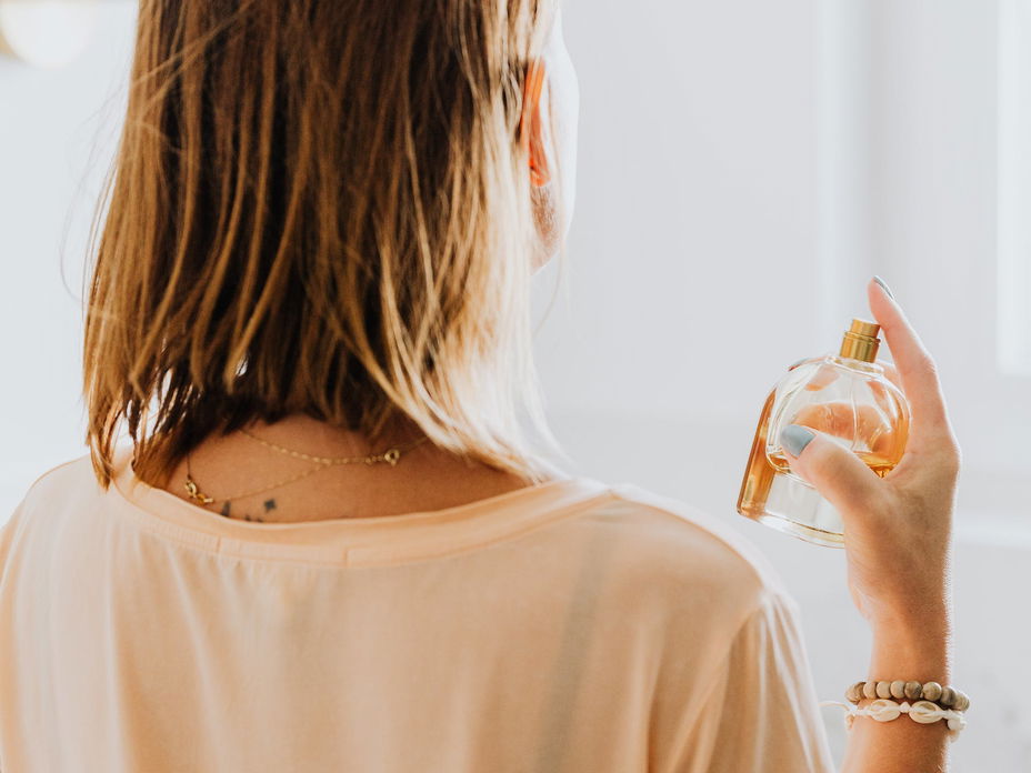 Frau sprüht Parfum wie frische Wäsche