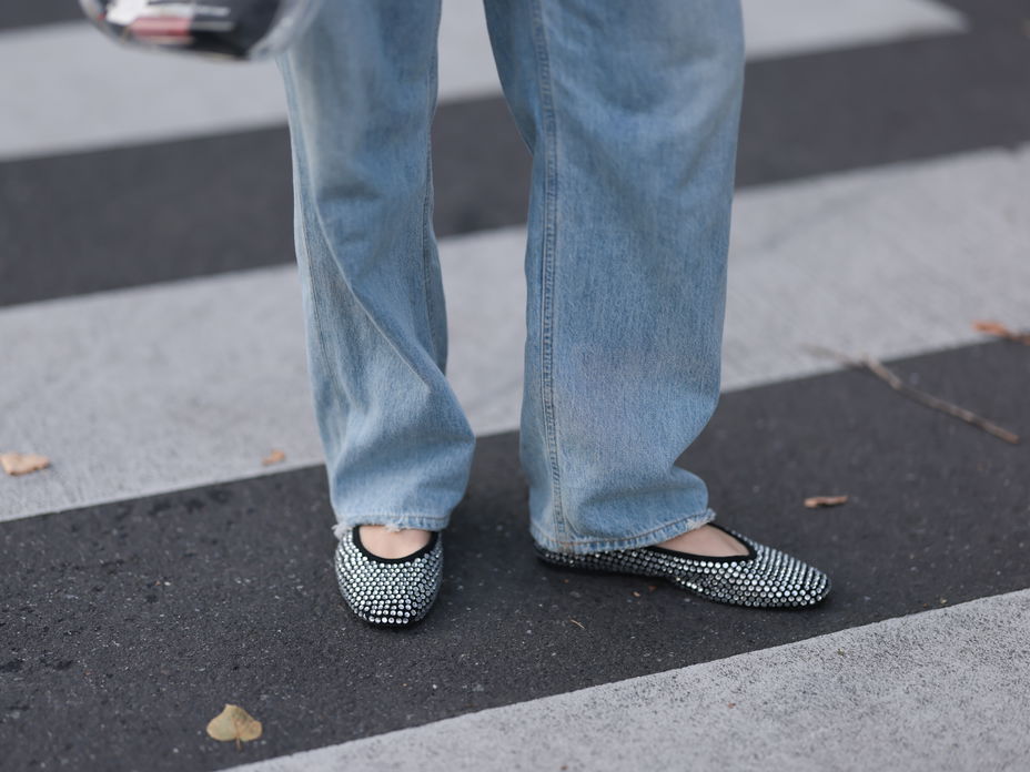 Frau trägt Party-Flats zu einer Jeans mit weitem Bein.