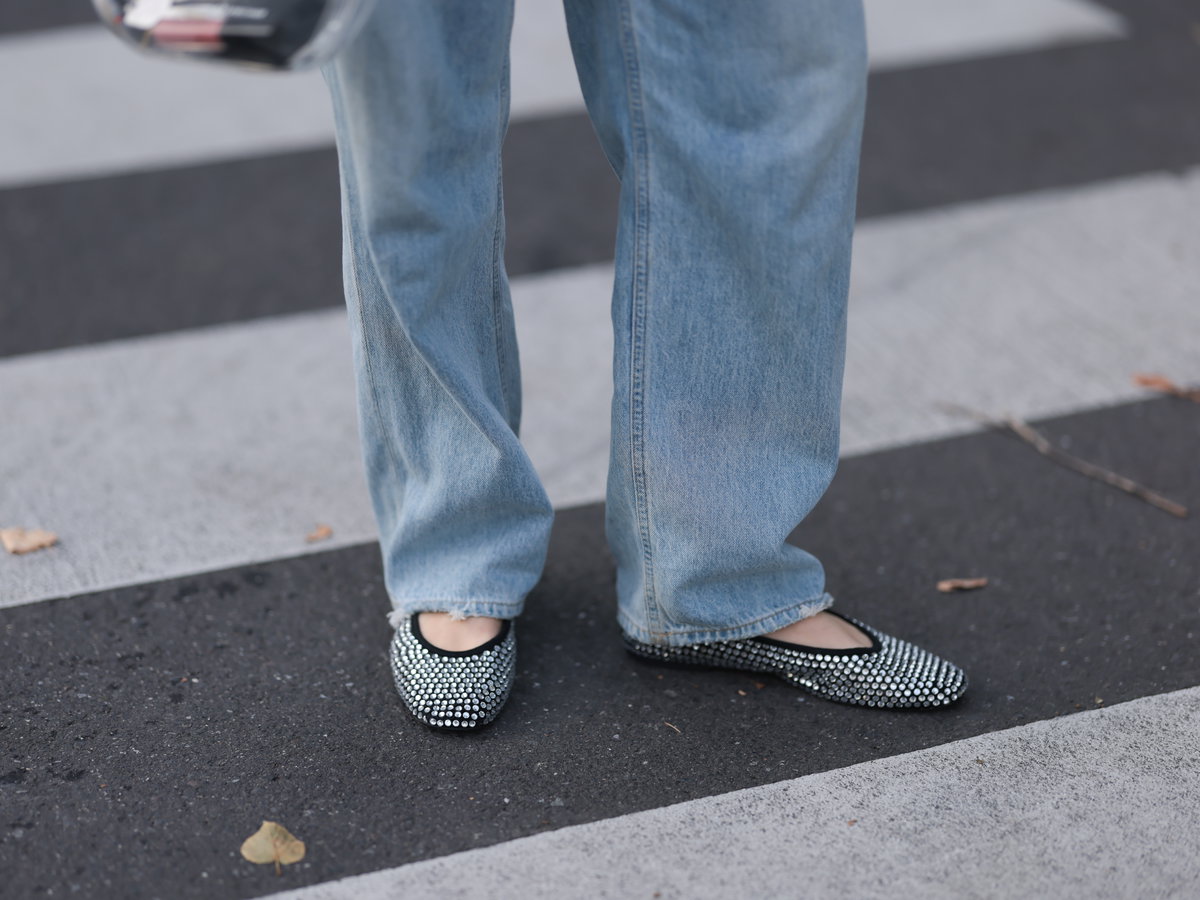 Frau trägt Party-Flats zu einer Jeans mit weitem Bein.