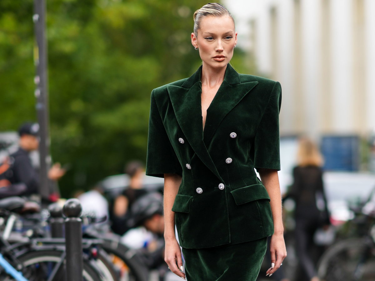 Frau trägt ein grünes Samtkleid im eleganten Streetstyle.