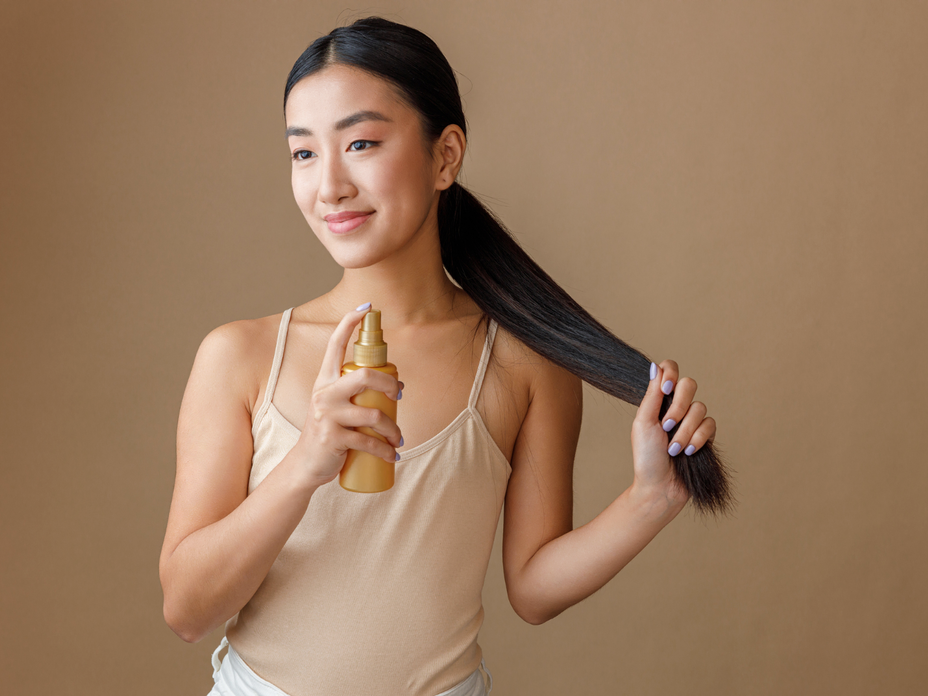 Frau mit Frizz-Spray von dm
