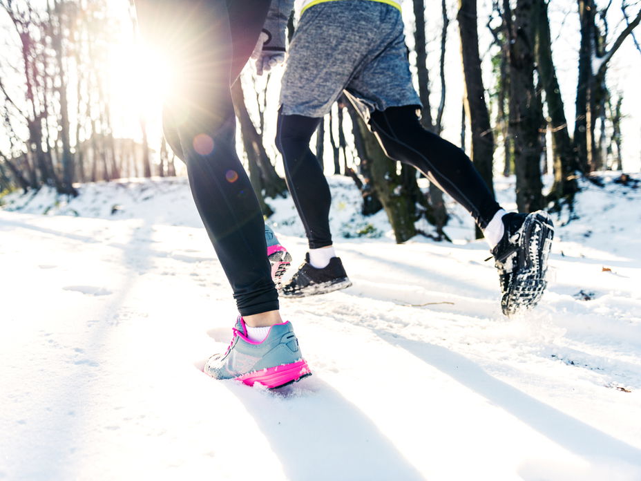 Zwei Personen joggen im Winter.