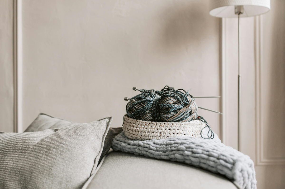 Stricknadeln und Wolle im Körbchen