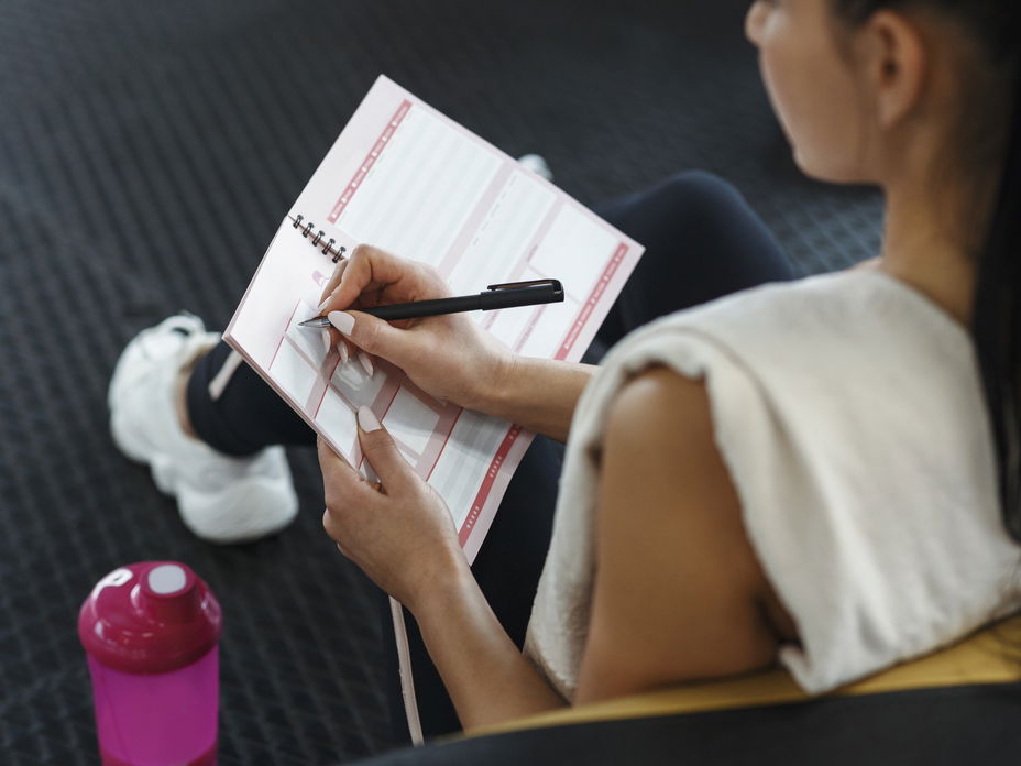 Frau schreibt sich einen Trainingsplan Ganzkörper