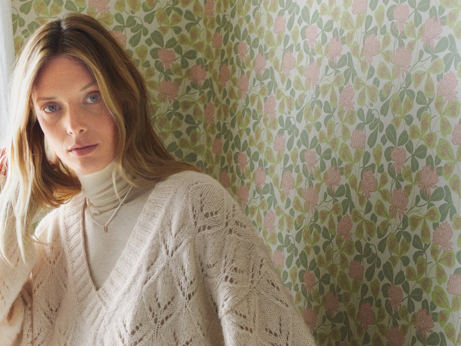 Model in gestricktem Ajourpullover