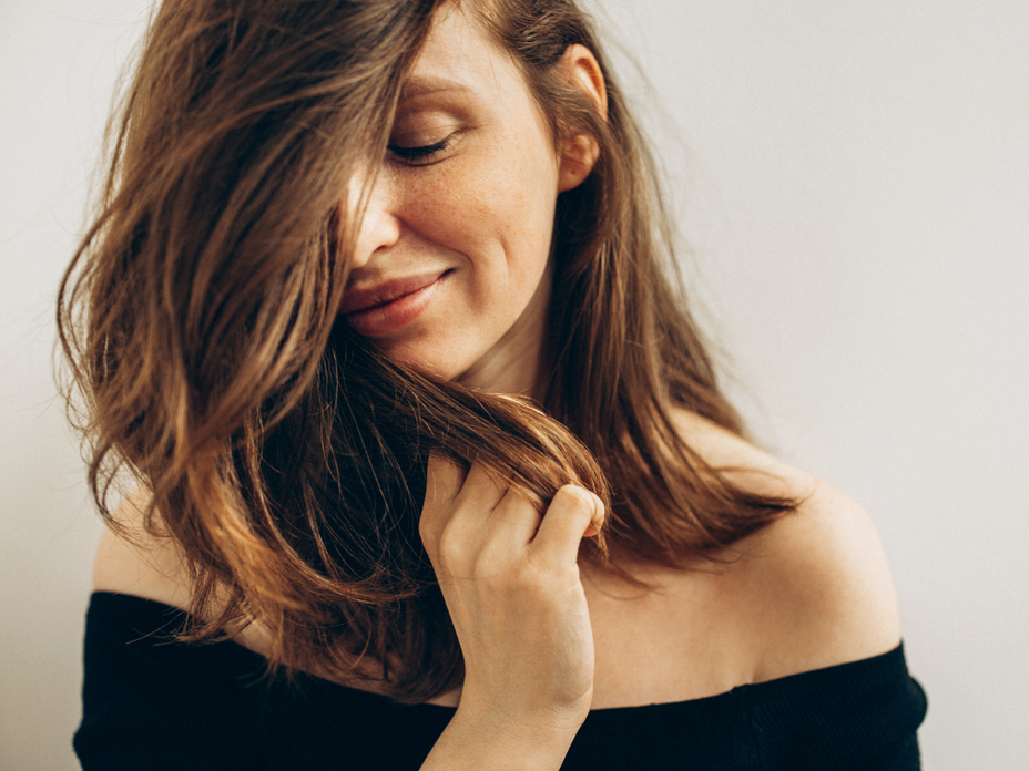 Frau mit Trockenshampoo in den Haaren