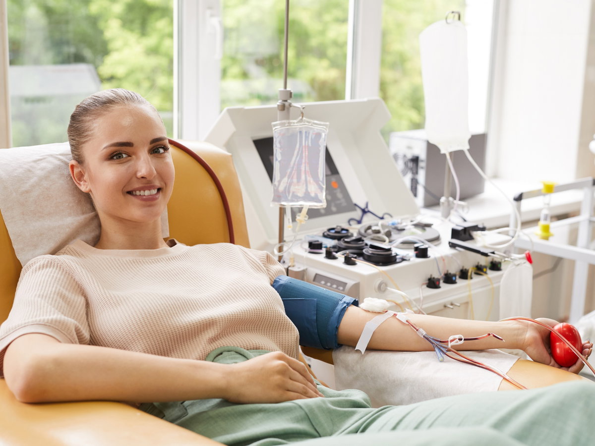 Frau liegt beim Blutspenden auf einem Sessel