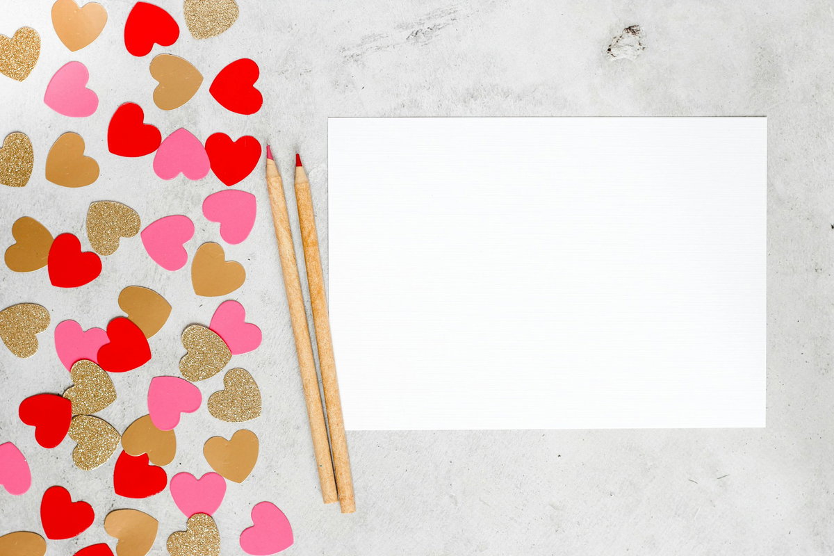 Ein Blatt Papier mit Herzen und Stiften