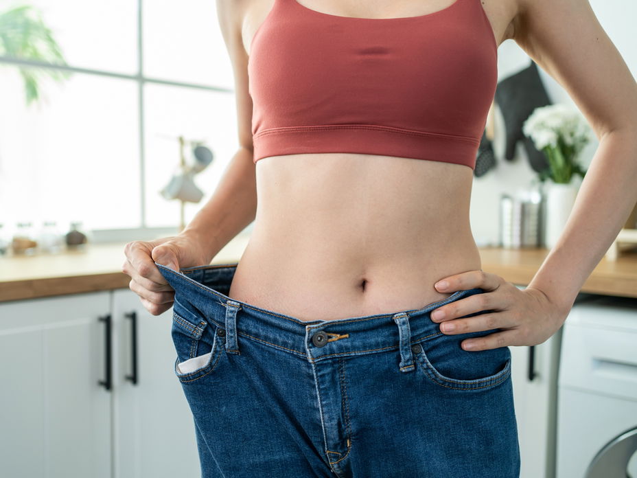 Frau trägt Hose, die zu groß am Bauch ist