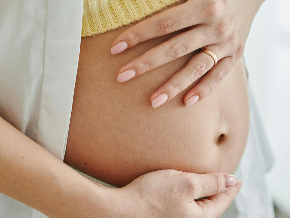 Frau streichelt ihren Babybauch
