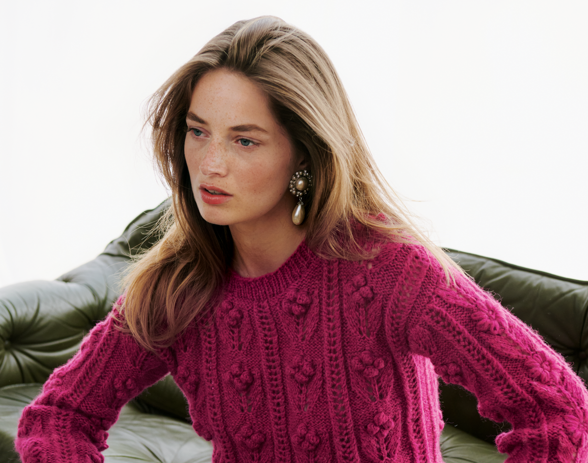 Model in Zopfmusterpullover mit Blüten von Lana Grossa
