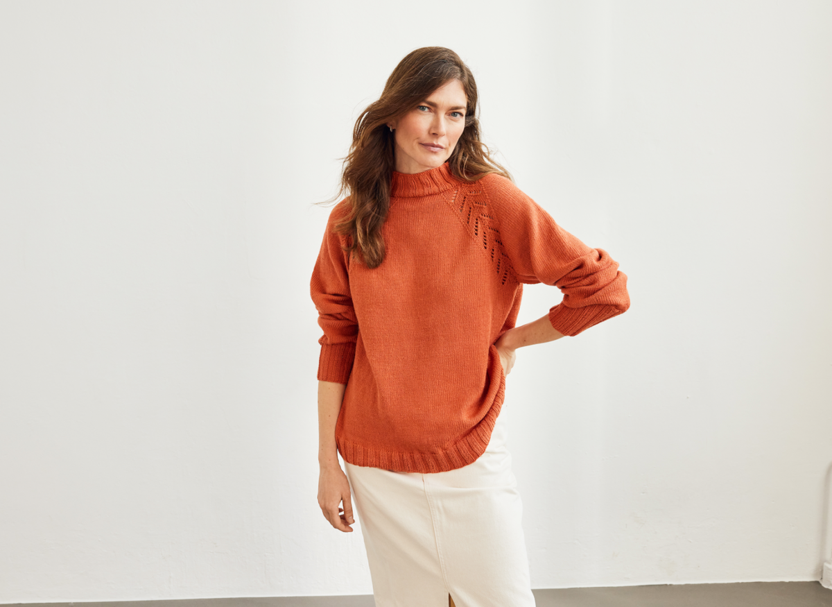 Model in orangefarbenem Lochmuster-Pullover von Lana Grossa