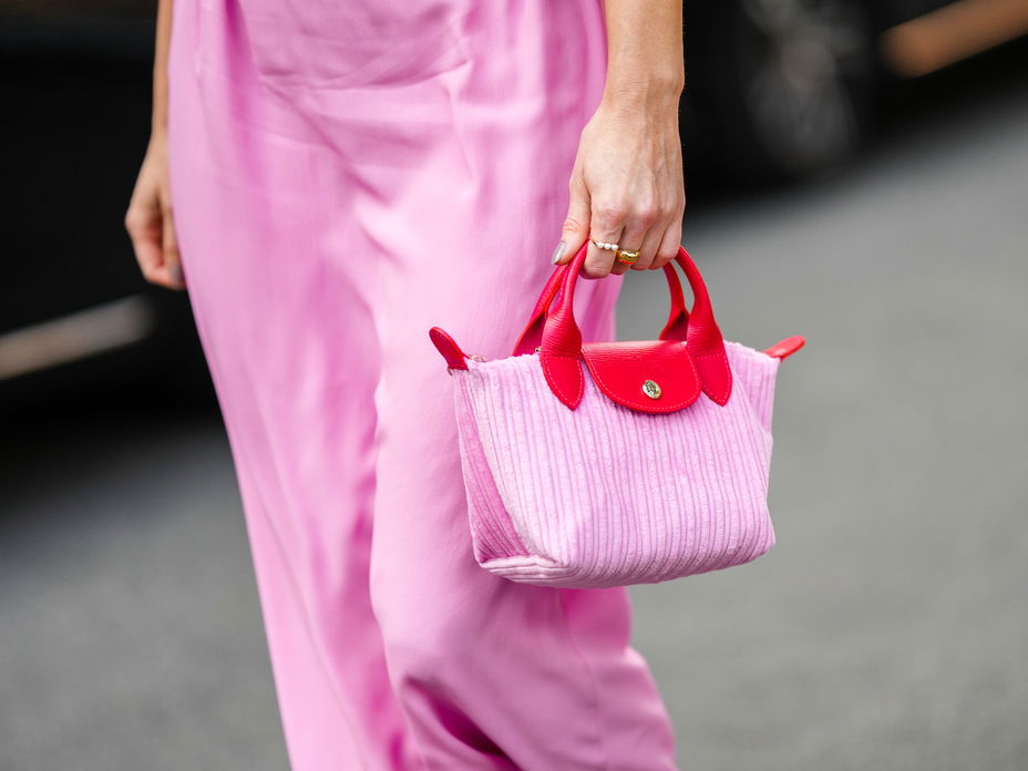 Frau trägt pinke Longchamp-Tasche im Streetstyle