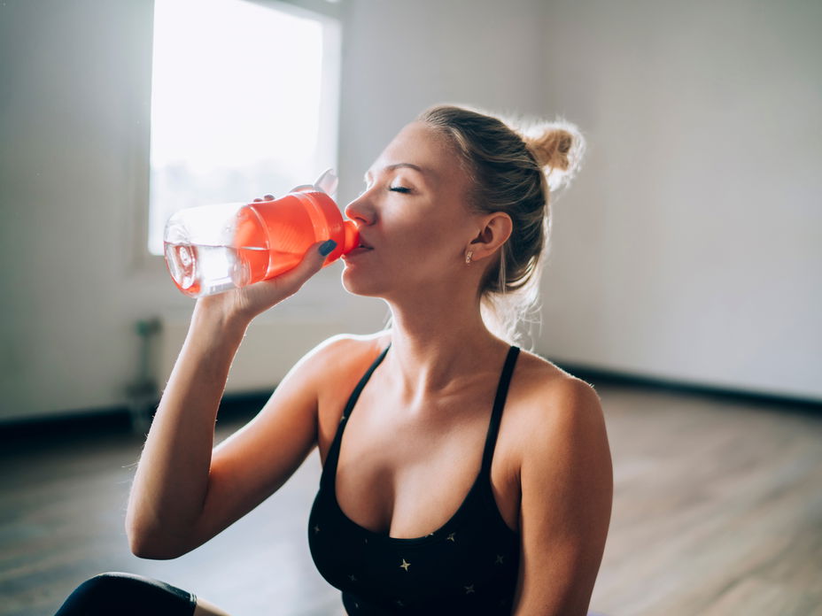 Frau trinkt aus einer Wasserflasche