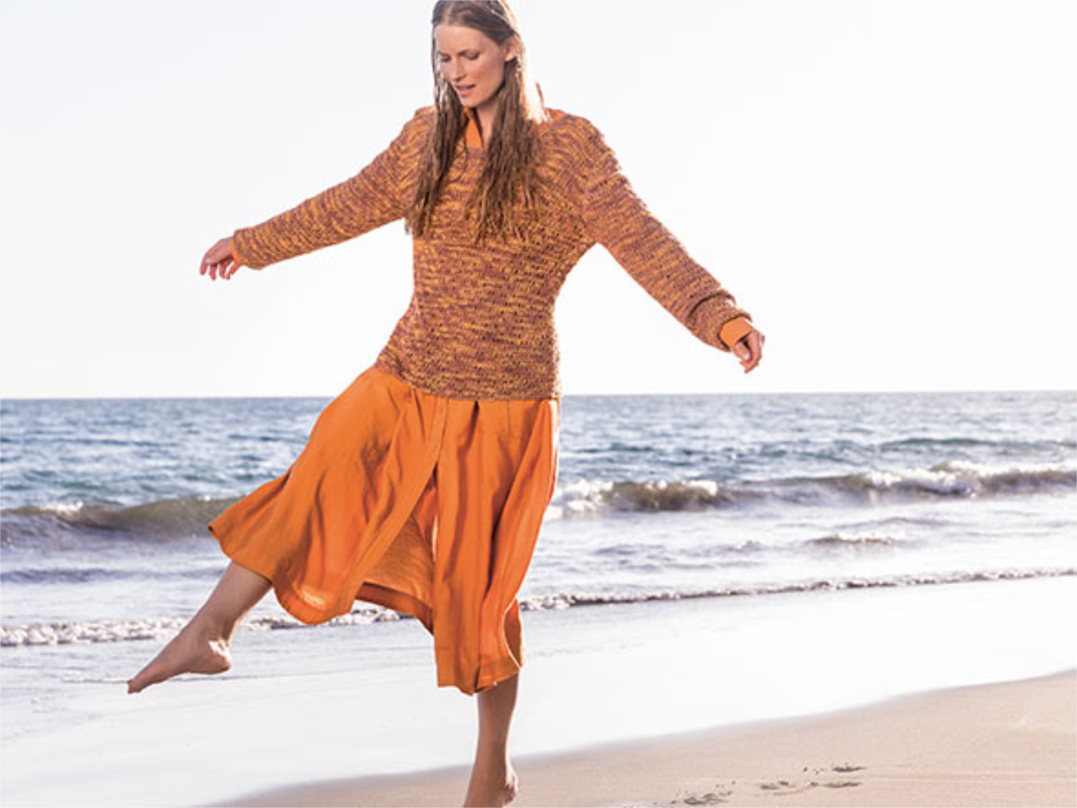 Model in orangefarbenem Sommerpullover