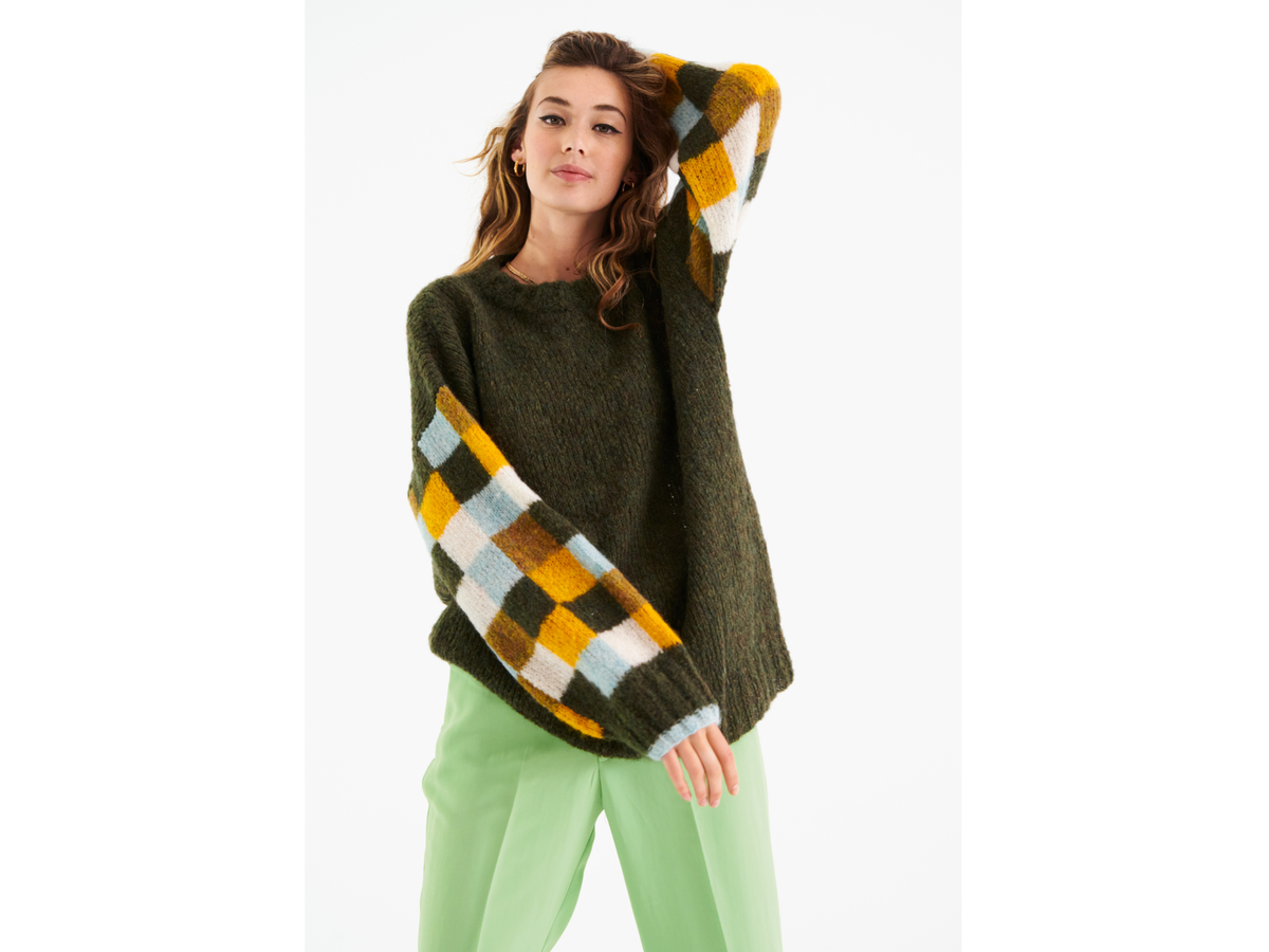 Model in moosgrünem Karo-Pullover von Lana Grossa