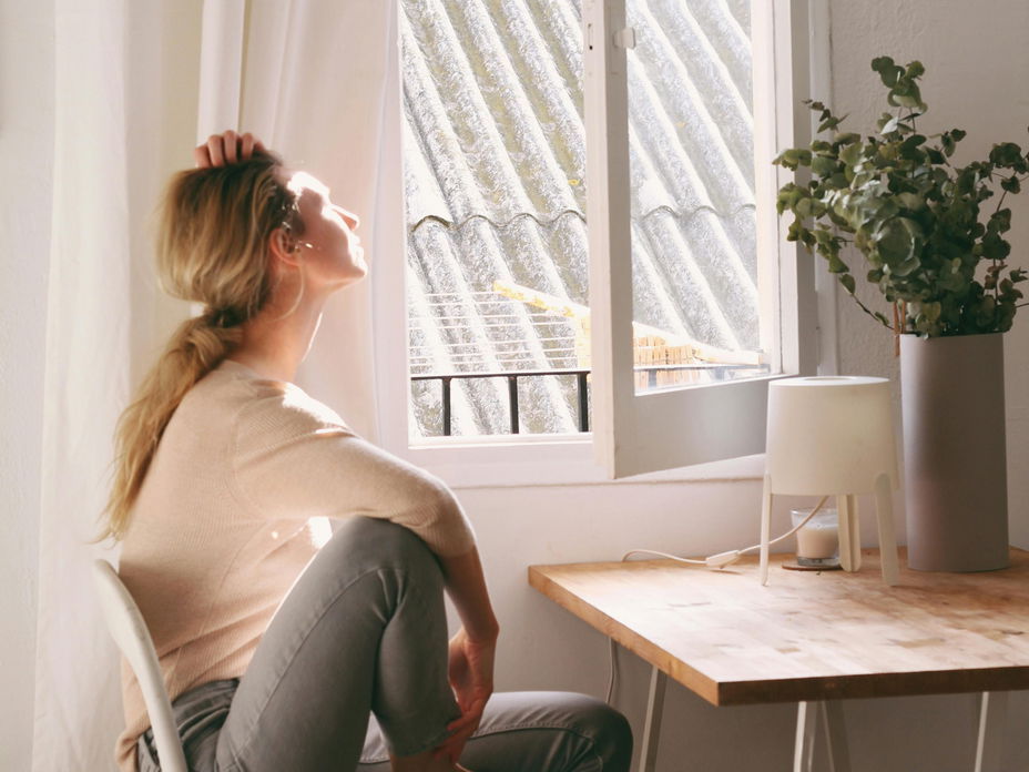 Frau an offenem Fenster