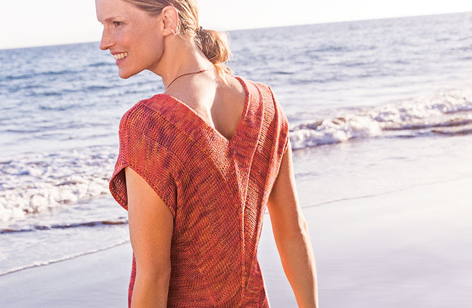 Modell in orangefarbenem Sommershirt von Lana Grossa