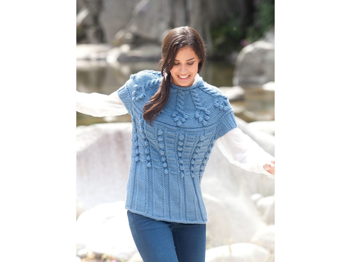 Model in hellblauem Sommershirt mit Bommelmuster