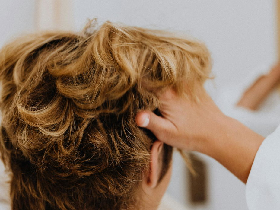 Frau geht sich mit den Fingern durch die Haare