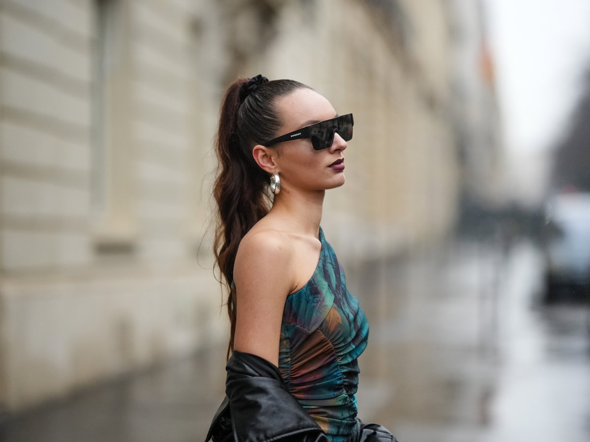 Frau mit hohem Zopf und Sonnenbrille