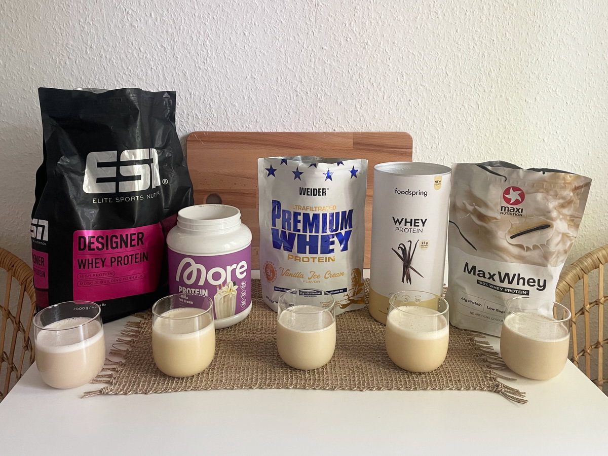 Fünf verschiedene Proteinpulver in der Verpackung und im Glas.