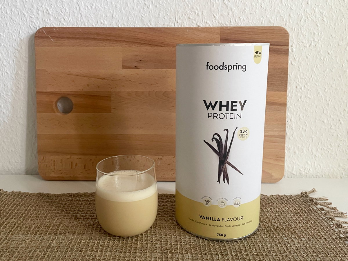 Whey Protein von foodspring in der Dose und im Glas.